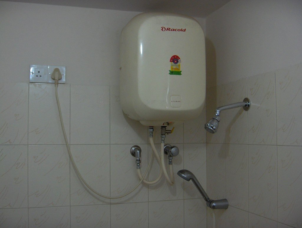 Electric water heater geyser mounted in a bathroom