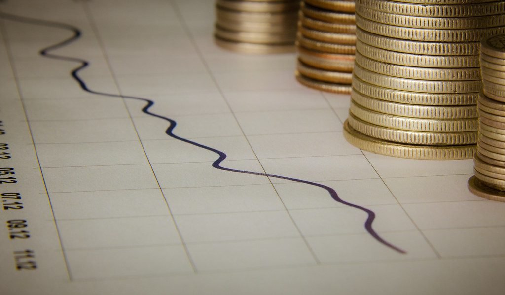Rising graph with stacks of coins representing stock investment